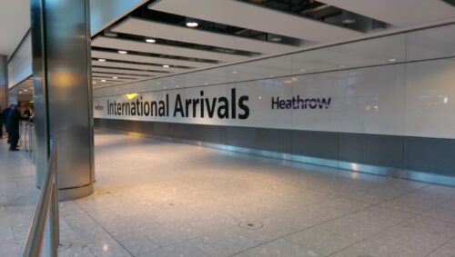 Letreiro International Arrivals no corredor de chegadas do aeroporto de Heathrow.