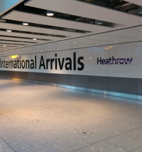 Letreiro International Arrivals no corredor de chegadas do aeroporto de Heathrow.