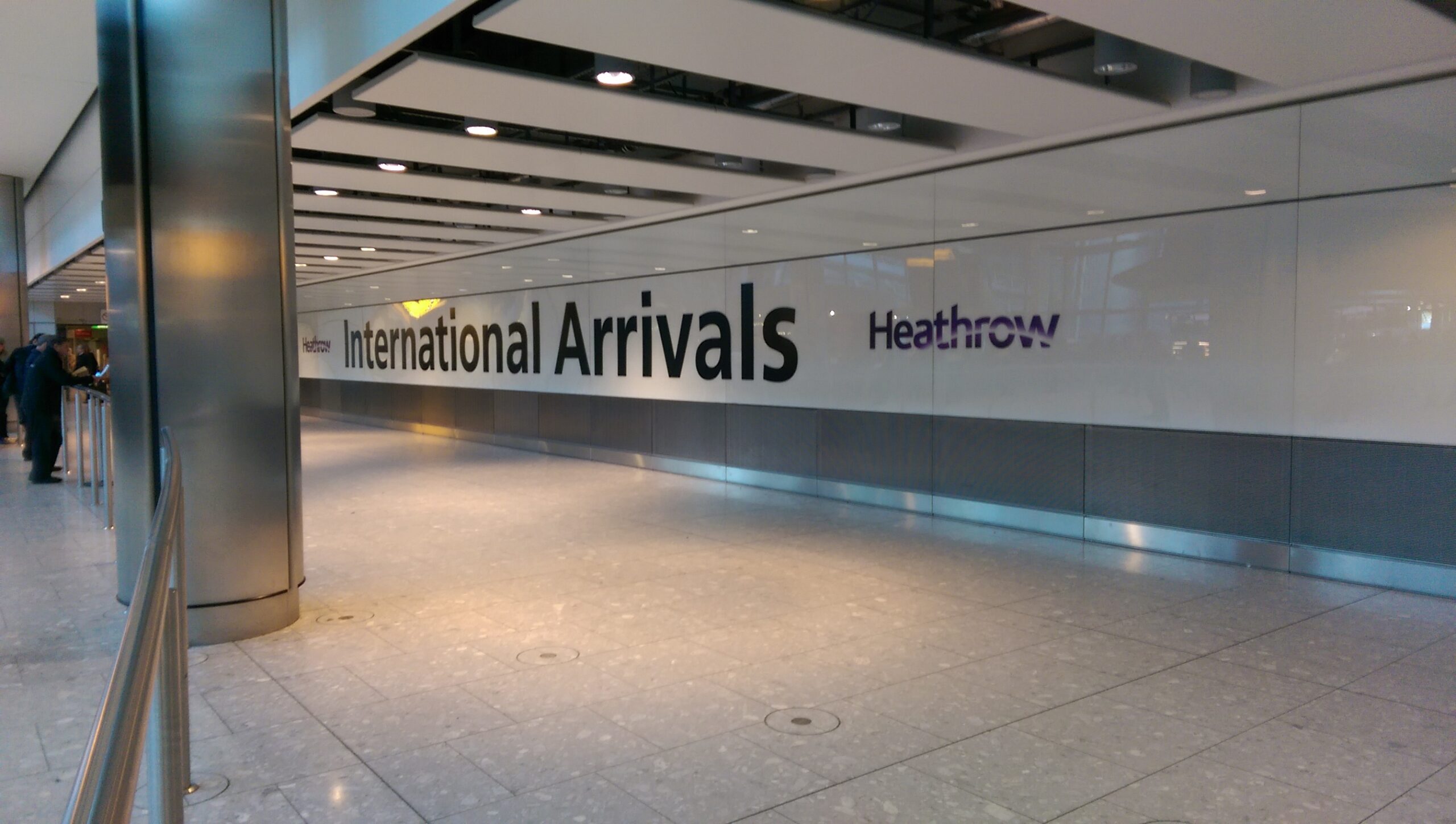 Letreiro International Arrivals no corredor de chegadas do aeroporto de Heathrow.