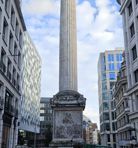 Coluna do Monument com urna dourada, entre edifícios da City de Londres; fotografia de arquivo de 2023