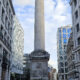 Coluna do Monument com urna dourada, entre edifícios da City de Londres; fotografia de arquivo de 2023